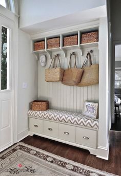 a white bench with baskets on it in a room