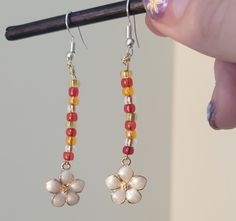 Red and gold beads white daisy flower charms drop dangle ear wire earrings Red Beaded Flower Shaped Jewelry, Adjustable Red Flower Beaded Earrings, Red Dangle Flower Earrings With Colorful Beads, Red Beaded Dangle Flower Earrings, Red Drop Earrings With Flower Charm, Red Flower Dangle Earrings With Colorful Beads, Gold Beaded Flower Earrings With Ear Wire, Gold Flower-shaped Beaded Earrings With Ear Wire, Gold Flower Earrings With Dangling Beads As Gift