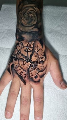 a man's hand with a clock tattoo on it