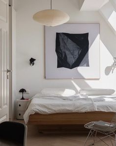 a bedroom with white walls and wooden floors