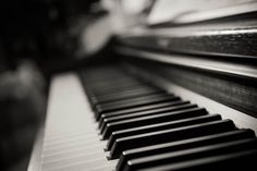 a close up view of the keys on an old piano with black and white tones