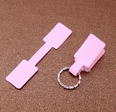 two pieces of pink paper sitting next to each other on a brown carpeted floor