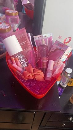 a red basket filled with personal care items on top of a counter next to a mirror