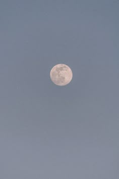 the full moon is visible in the clear sky