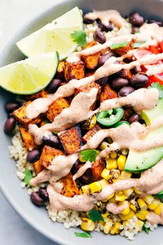 a bowl filled with rice, black beans, avocado and taco sauce