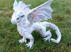 a white dragon statue sitting in the grass