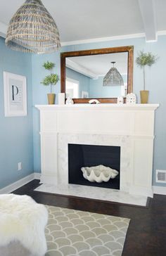 a living room with a white fireplace and blue walls