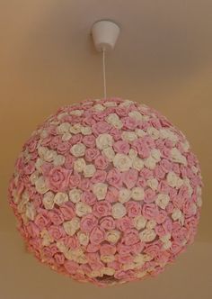 a pink and white flowered chandelier hanging from a ceiling