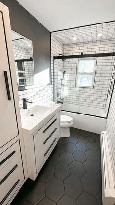 a bathroom with black and white tiles on the walls, floor, and vanity area