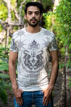 The Twin Tiger shirt is men’s Tee with a sak yant print. Often seen in traditional Thai tattoos, the image of twin tigers represents strength and power. Handmade from soft cotton this T-shirt is printed on both front and back, has short sleeves and a round neck. Pattern In Thailand the twin tigers are often seen tattooed on people with dangerous occupations such as Muay Thai fighters. It is common belief that the twin tigers will give strength, power and protection. Always Vegan and Fair Trade O Traditional White Cotton T-shirt, Traditional Thai Tattoo, Thai Tattoos, Thai Harem Pants, Famous Guys, Fisherman Pants, Thai Tattoo, Sak Yant, Tiger Shirt