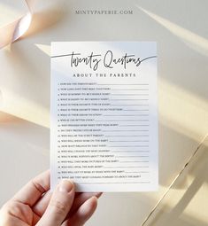 someone holding up a printable twenty questions about the parents game on their wedding day