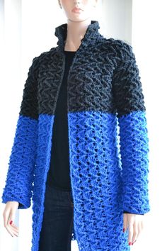 a mannequin is wearing a blue and black crochet coat with hood