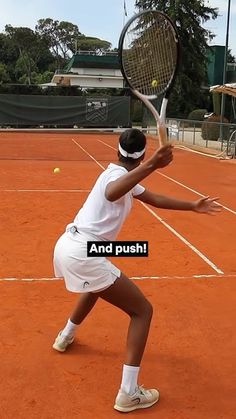 a tennis player is about to hit the ball with her racket on an orange clay court