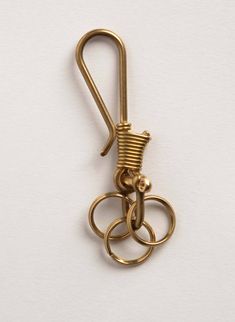 a gold colored metal object hanging from a hook