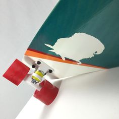 a skateboard with an animal painted on it's side and two red wheels