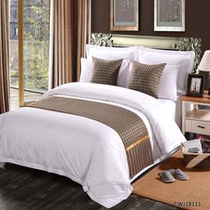 a bed with white sheets and brown pillows