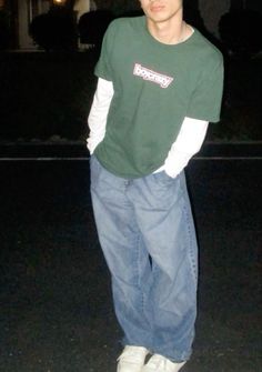 a young man standing in the street at night