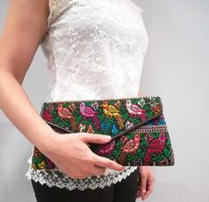 Our popular Atitlan Street Amelie clutch represents elegance, luxury and class. This clutch is designed to dazzle, combining the original and artistic qualities of the handmade floral and avian-styled huipil with leather, all in a classic letterbox design.  It is divided into two compartments, one with a zippered pocket for your personal cards and keys and the other one for your essentials, ideally compact for cocktails and dinners!  It comes with a fully detachable cross-body strap transforming Elegant Handwoven Clutch Shoulder Bag, Bohemian Multicolor Embroidery Clutch, Bohemian Evening Rectangular Clutch, Elegant Handwoven Shoulder Bag For Party, Elegant Handwoven Shoulder Bag For Gift, Elegant Handwoven Party Bag, Elegant Multicolor Embroidered Shoulder Bag, Handmade Shoulder Bag For Formal Occasions, Bohemian Embroidered Clutch Evening Bag