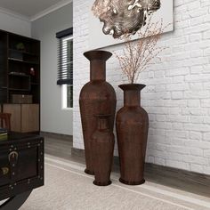 two brown vases sitting next to each other in front of a white brick wall