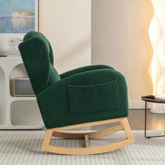 a green rocking chair sitting on top of a rug in front of a wall mounted painting