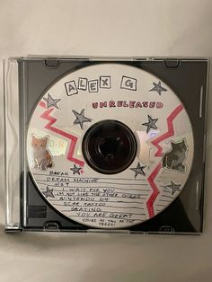 a cd that is sitting on top of a wall with writing on it and an image of a dog