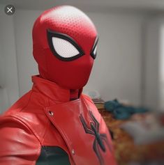 a close up of a person wearing a red spider man costume with black eyes and ears