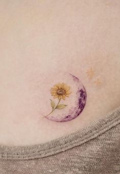 a woman's stomach with a small sunflower on the side of her belly