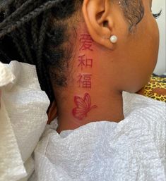 the back of a woman's head with chinese writing on her neck and behind her ear