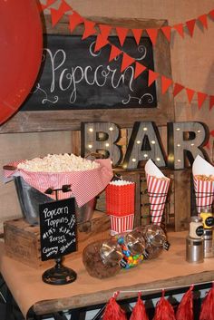 popcorn bar with red and white striped paper cups, candy bars, and other items