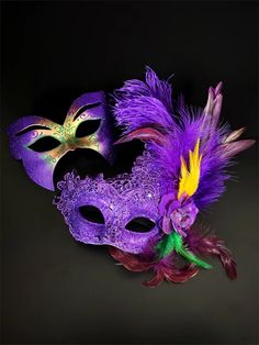 a purple mask with feathers and a flower on the side, against a black background