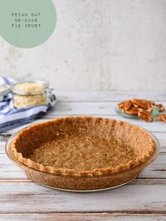 a pie crust in a bowl on a table with pecans and other food items