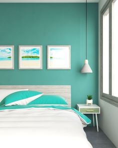 a bedroom with teal walls and white bedding, two pictures on the wall