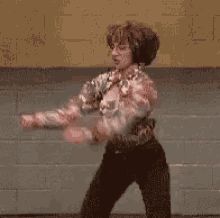 a woman is dancing in front of a brick wall with the words friday on it