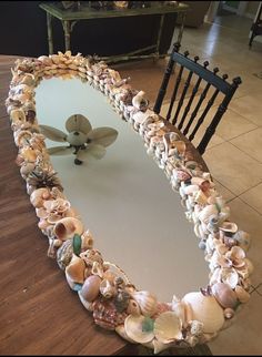 there is a mirror made out of seashells on the floor