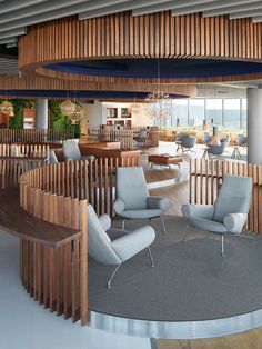 a circular room with chairs and tables in the center, along with wooden railings