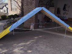 an upside down blue and yellow tent in front of a house