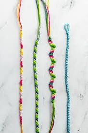 three colorful necklaces on a white surface with one beaded and the other knotted