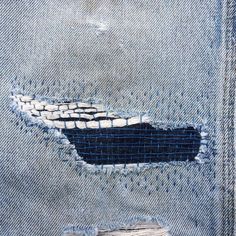 an old pair of jeans with torn edges and patches on the bottom, revealing a black patch in the middle