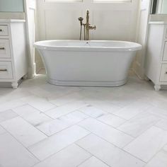 a white bath tub sitting next to two windows