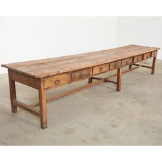 an old wooden table with three drawers on one side and two smaller drawers on the other