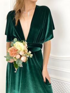 a woman in a green dress holding a flower bouquet