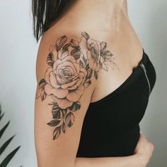 a woman with a rose tattoo on her arm and shoulder is looking at the camera