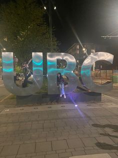 a woman is standing in front of the letters