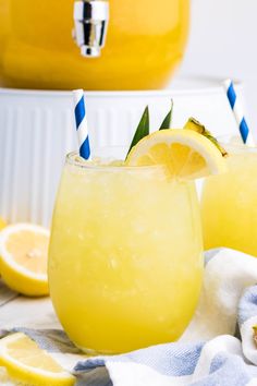 two glasses filled with lemonade on top of a table