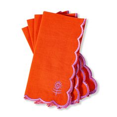 four orange napkins with pink trim on them