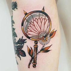 a woman's thigh with a flower and a magnifying glass on it