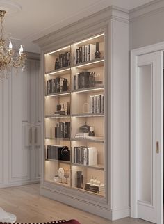 a large book case with many books on it's shelves next to a chandelier