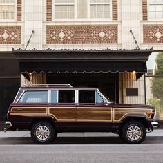 a brown and black jeep parked in front of a building