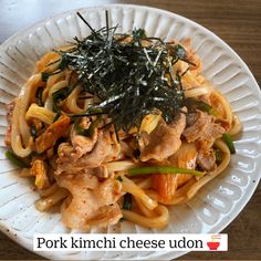 a white plate topped with pasta and meat