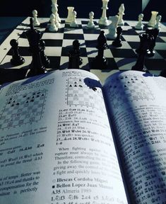 an open book sitting on top of a chess board